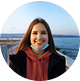 Woman smiling near ocean at sunset