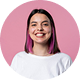 Smiling person with pink hair, pink background.