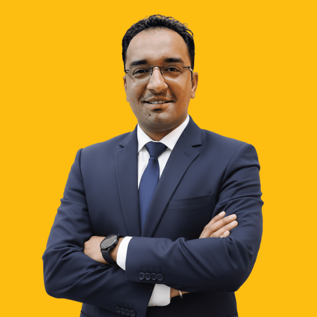 Man in suit with orange background, smiling confidently.